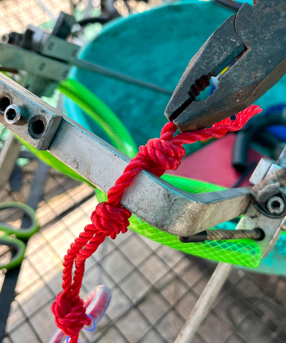 Tied to frame and pulled tight with pliers